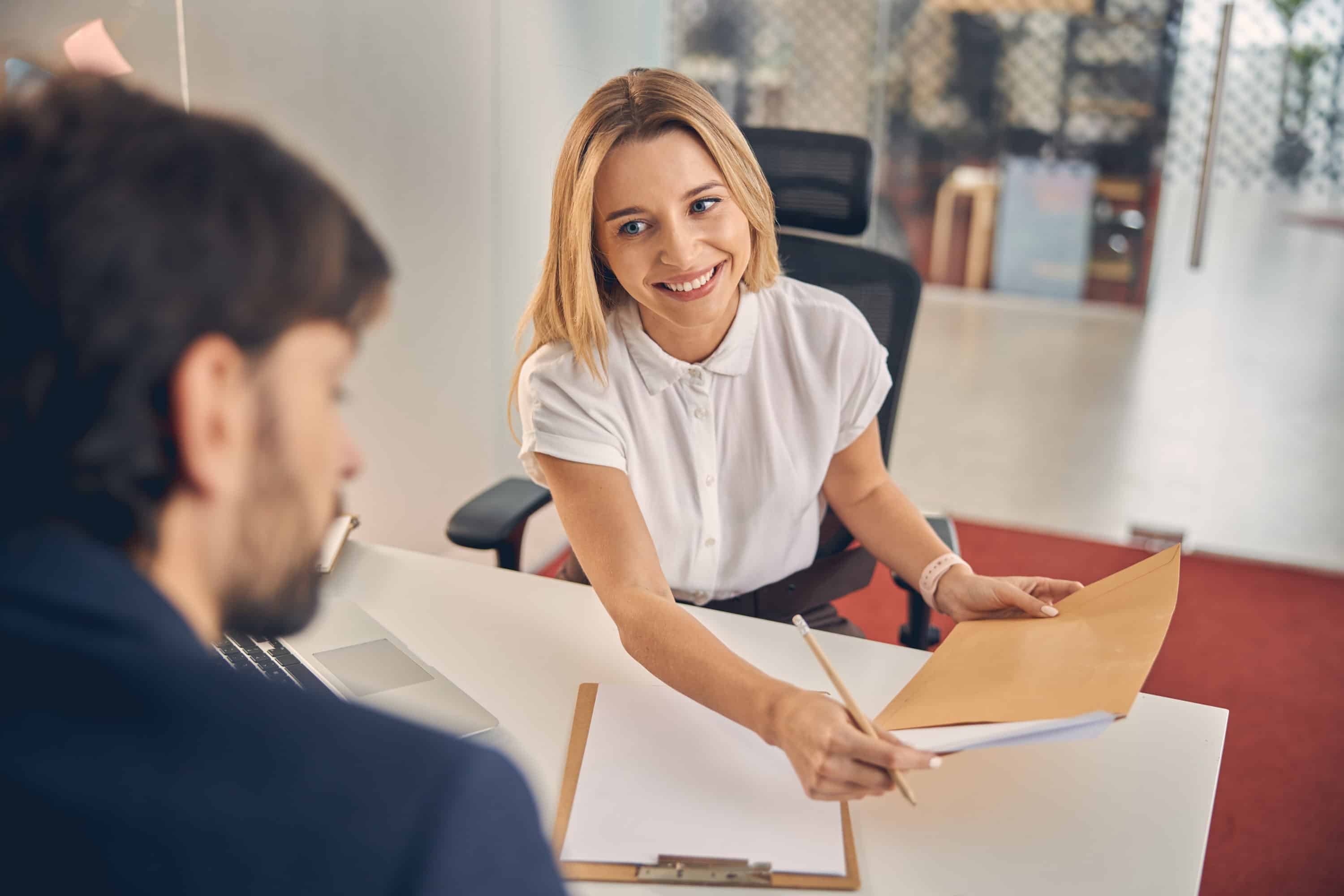 Joyful young woman having meeting with client in office Devanture Hotel de Ville